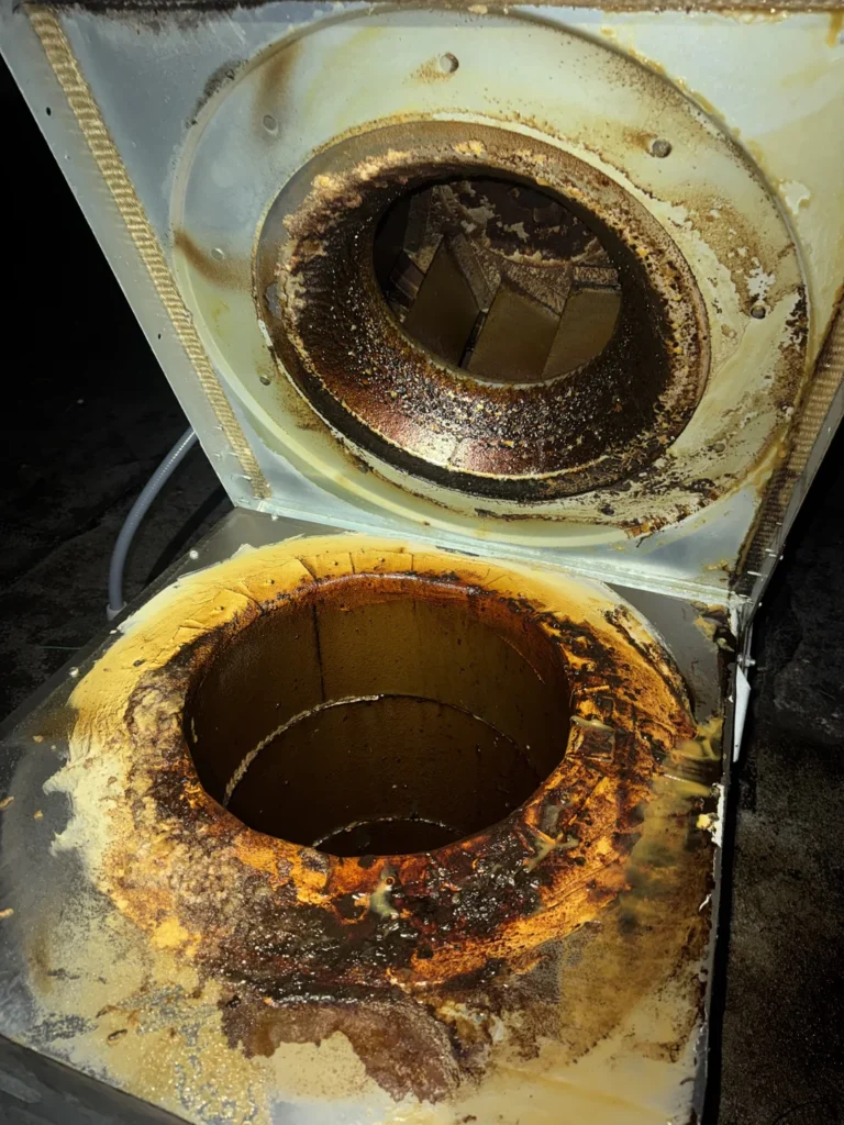 Grease buildup on a rooftop kitchen exhaust fan before cleaning
